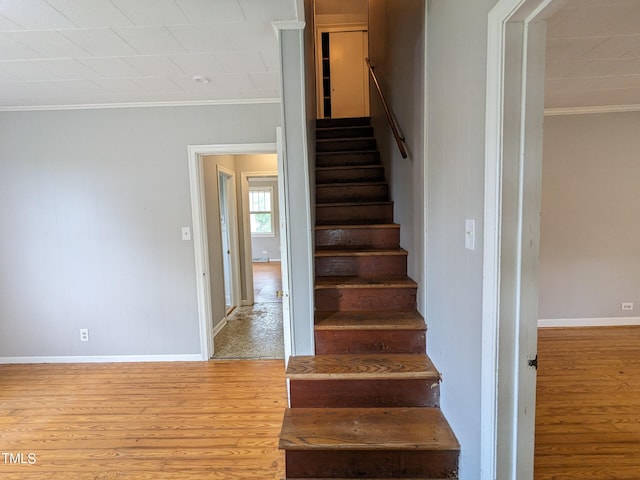 stairway featuring hardwood / wood-style flooring and crown molding