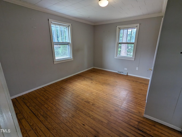 unfurnished room with hardwood / wood-style flooring, crown molding, and a healthy amount of sunlight