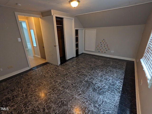 unfurnished bedroom featuring vaulted ceiling and a closet