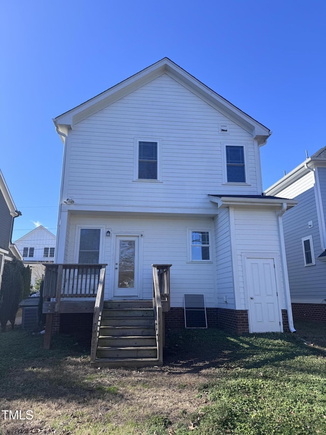 back of house with a wooden deck and a lawn