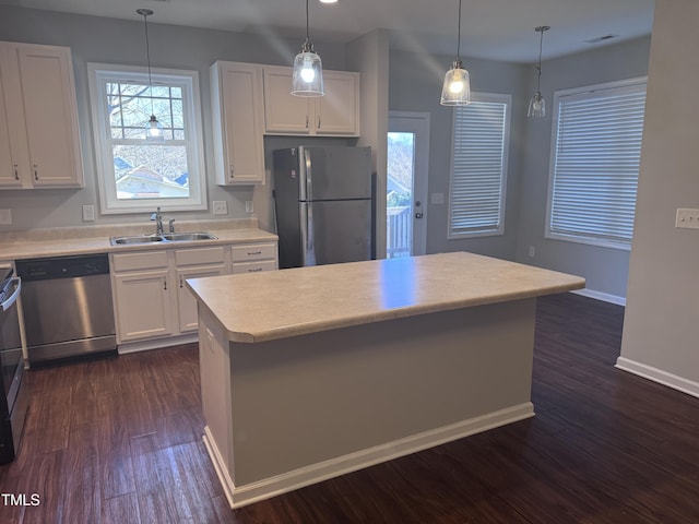 kitchen featuring white cabinets, a center island, sink, and appliances with stainless steel finishes