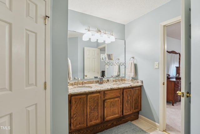 bathroom featuring a textured ceiling, tile patterned floors, and vanity