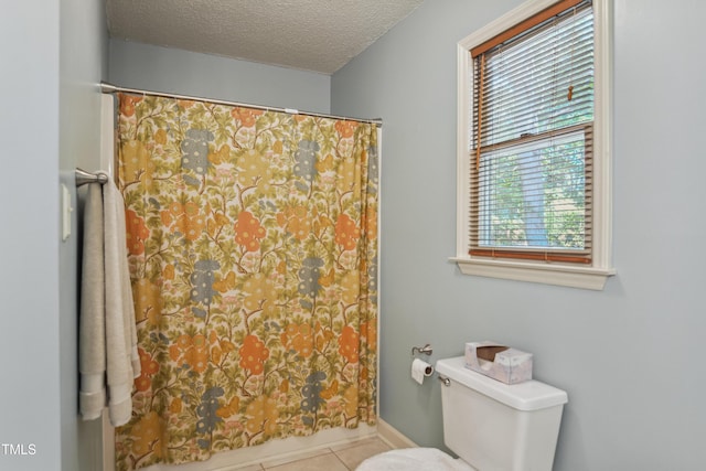 bathroom with a shower with shower curtain, toilet, a textured ceiling, and tile patterned flooring