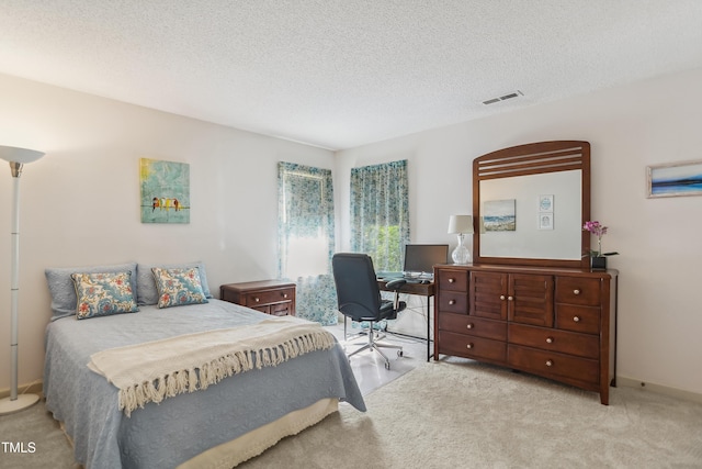 bedroom with a textured ceiling and light carpet