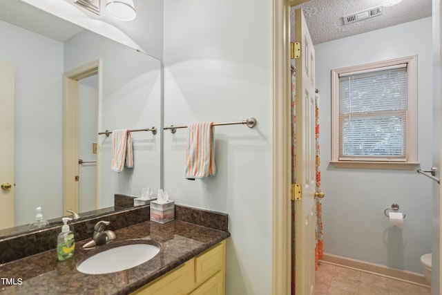 bathroom featuring a textured ceiling, toilet, and vanity