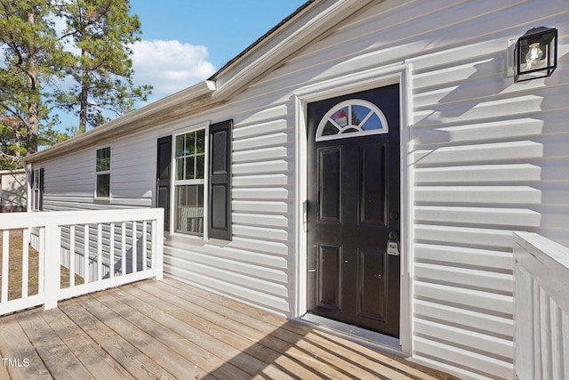 view of exterior entry with a wooden deck