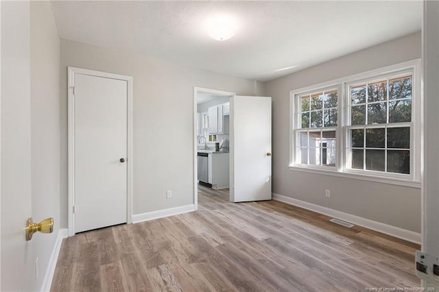 unfurnished bedroom featuring light hardwood / wood-style flooring and sink