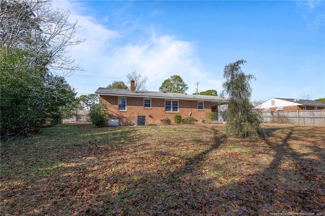 back of property with a yard and central AC unit