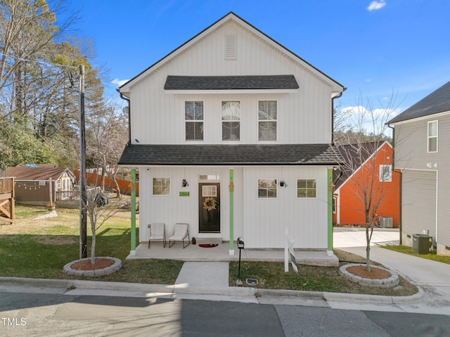 view of front of property with a front lawn and central air condition unit