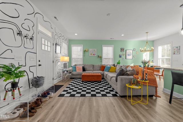 living room with light hardwood / wood-style flooring and an inviting chandelier