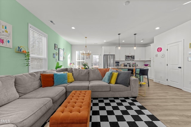 living room featuring light hardwood / wood-style flooring and a chandelier