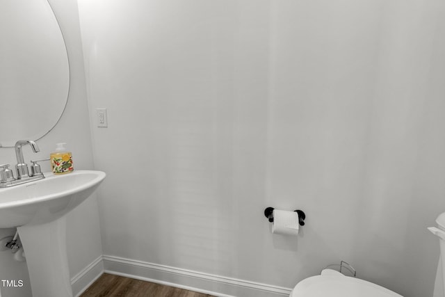 bathroom with hardwood / wood-style flooring and toilet