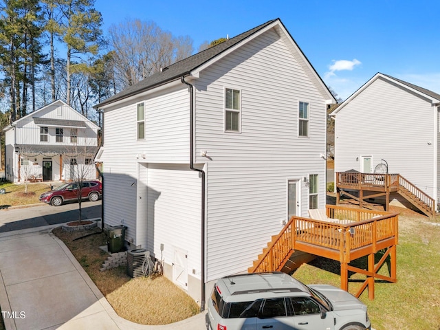 view of side of property with central AC unit and a deck