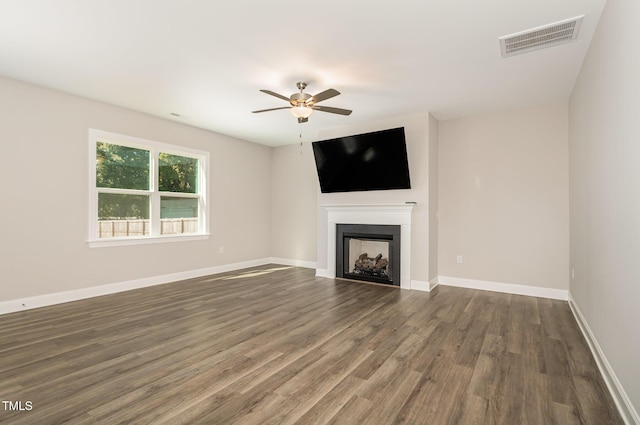 unfurnished living room featuring dark hardwood / wood-style floors and ceiling fan