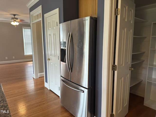 kitchen featuring ceiling fan, stainless steel fridge, wood-type flooring, and ornamental molding