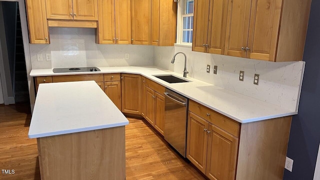 kitchen featuring backsplash, black electric stovetop, sink, stainless steel dishwasher, and light wood-type flooring