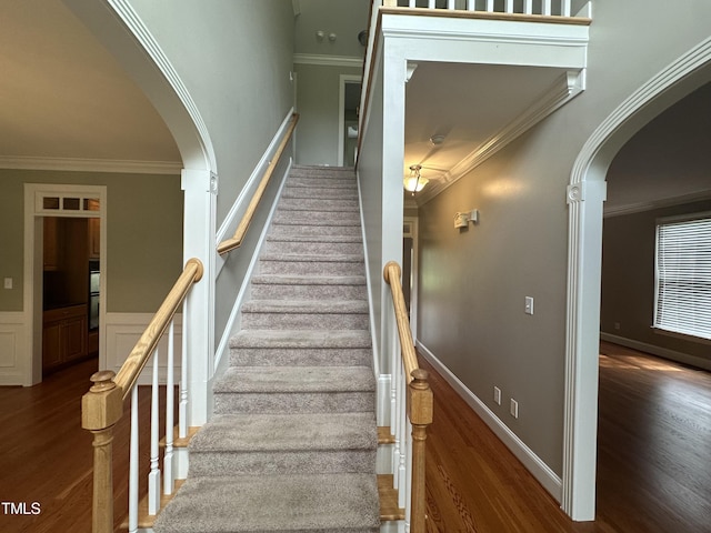 staircase with hardwood / wood-style floors and ornamental molding