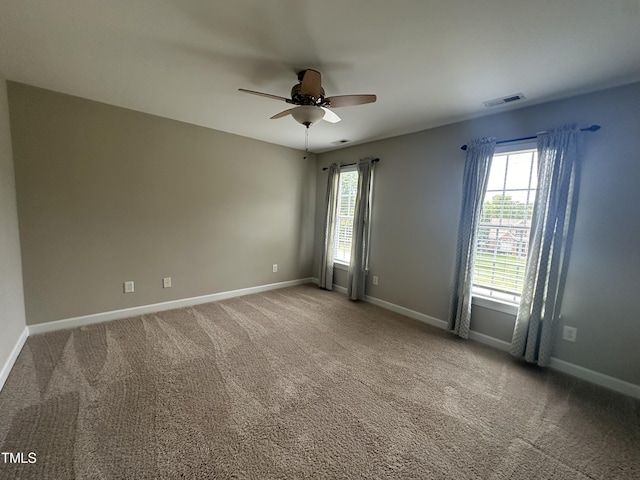 carpeted spare room with ceiling fan and a healthy amount of sunlight