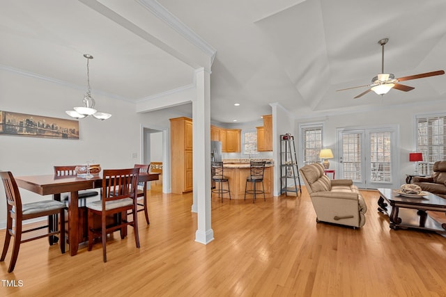 dining room featuring ceiling fan with notable chandelier, decorative columns, ornamental molding, and light hardwood / wood-style flooring