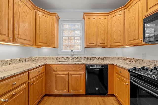 kitchen featuring light stone countertops, light wood-type flooring, crown molding, sink, and black appliances