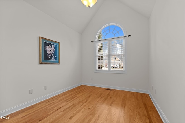 spare room featuring hardwood / wood-style flooring and lofted ceiling