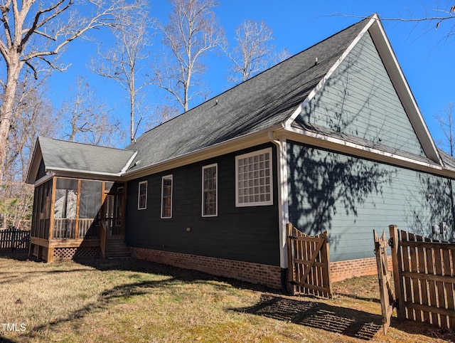 view of home's exterior featuring a sunroom and a yard