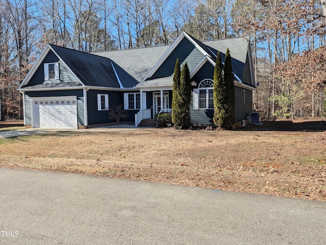 view of front of home featuring a front yard, a garage, and cooling unit