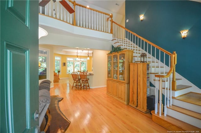 654 Titmouse Ct, Vass, NC 28394 - stairs featuring a towering ceiling, wood finished floors, a chandelier, and a ceiling fan