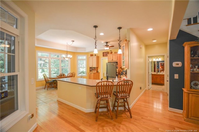654 Titmouse Ct, Vass, NC 28394 - kitchen featuring freestanding refrigerator, light wood-style flooring, glass insert cabinets, a peninsula, and a ceiling fan