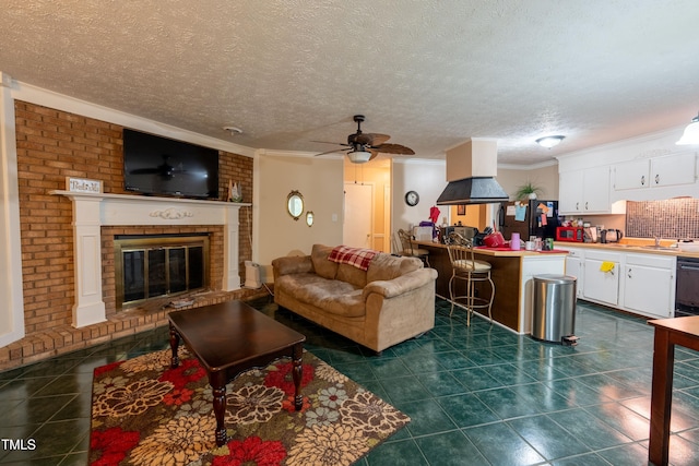 tiled living room featuring ceiling fan, sink, a textured ceiling, a fireplace, and ornamental molding