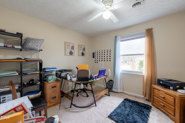 carpeted office space featuring a textured ceiling and ceiling fan