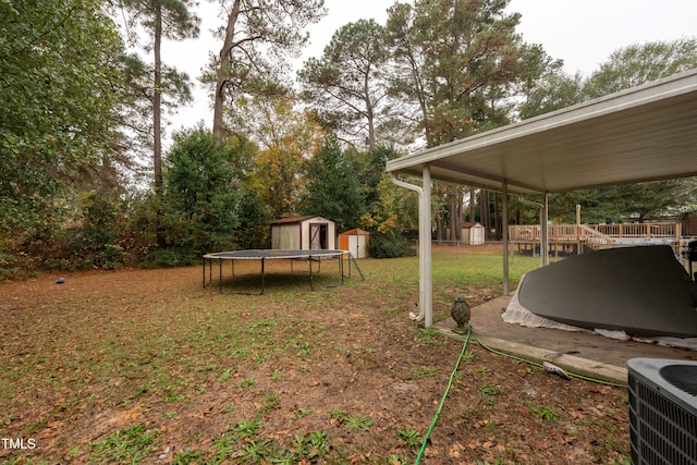 view of yard with central AC, a shed, and a trampoline