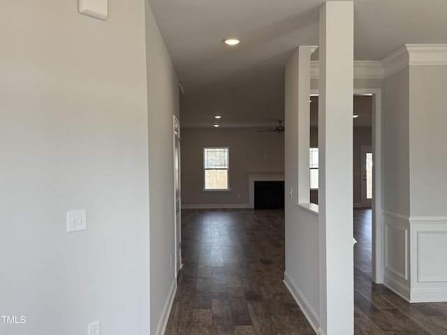 corridor with crown molding, dark wood finished floors, recessed lighting, wainscoting, and baseboards