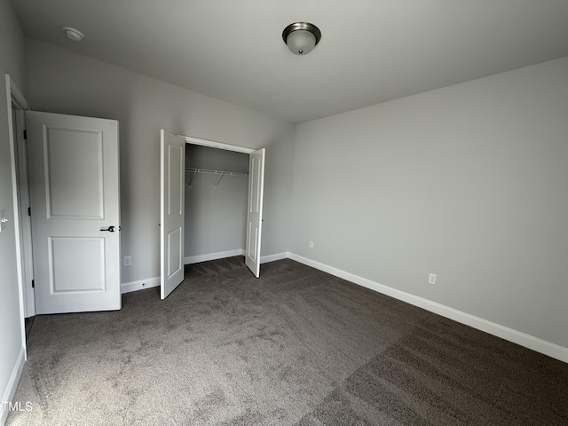 unfurnished bedroom with carpet, baseboards, and a closet