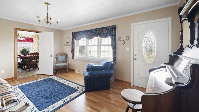 entrance foyer featuring hardwood / wood-style floors, an inviting chandelier, and ornamental molding