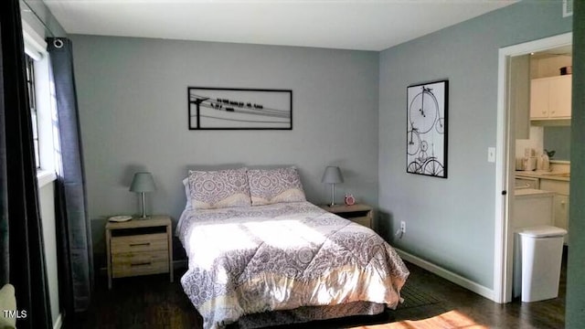 bedroom featuring multiple windows, ensuite bathroom, and dark hardwood / wood-style floors