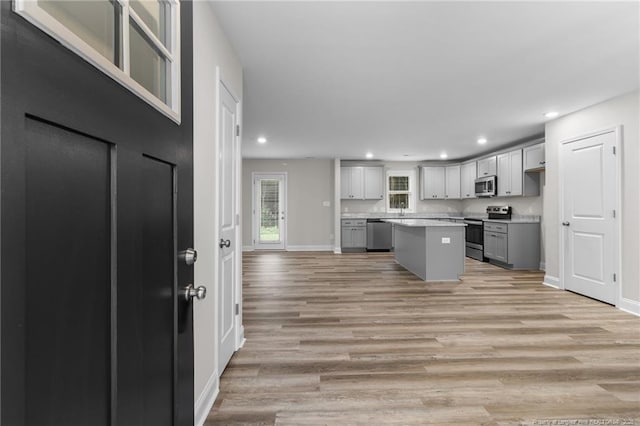 kitchen featuring a center island, gray cabinets, light hardwood / wood-style floors, and appliances with stainless steel finishes