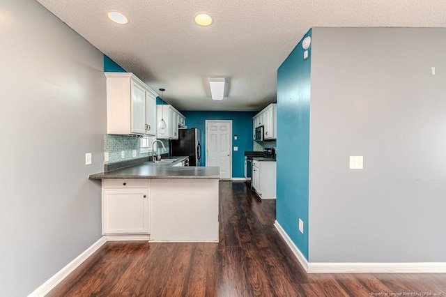 kitchen featuring dark hardwood / wood-style flooring, tasteful backsplash, a textured ceiling, stainless steel appliances, and white cabinetry