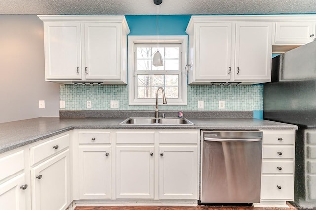 kitchen featuring white cabinetry, stainless steel dishwasher, hanging light fixtures, and sink