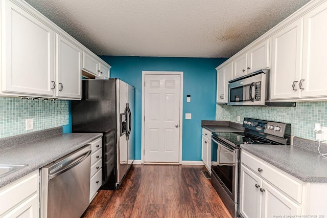 kitchen featuring tasteful backsplash, a textured ceiling, stainless steel appliances, dark hardwood / wood-style floors, and white cabinetry