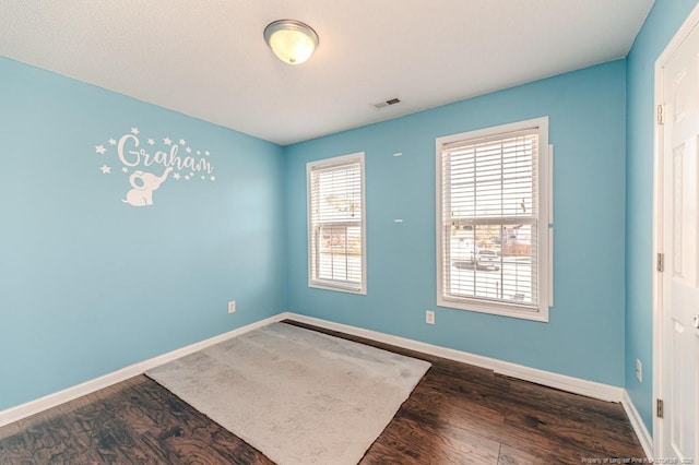 spare room with dark hardwood / wood-style flooring