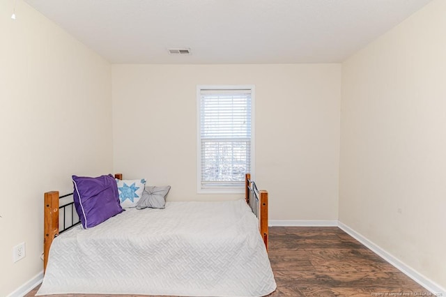 bedroom with dark hardwood / wood-style flooring