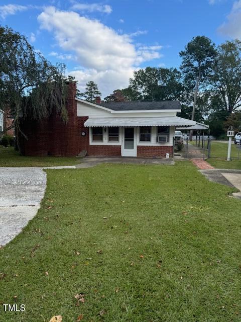 view of front of property with a front yard and a carport