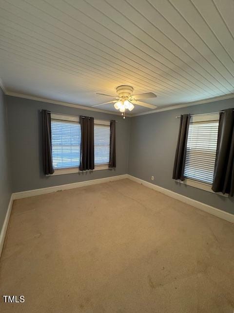 carpeted spare room featuring ceiling fan and crown molding