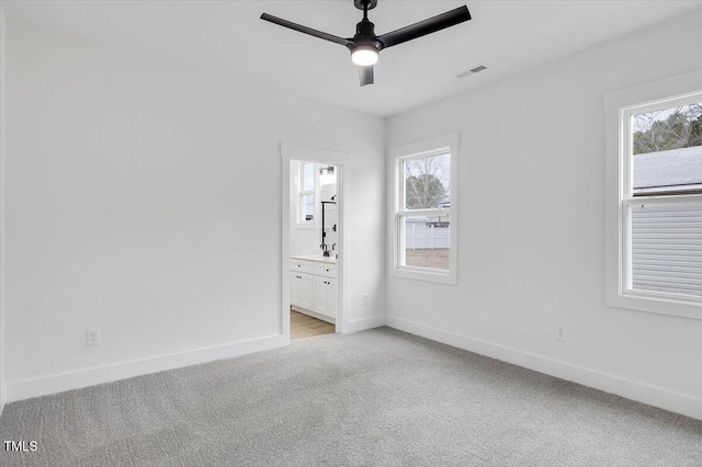 carpeted spare room with ceiling fan and a healthy amount of sunlight