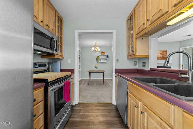 kitchen featuring stainless steel appliances, dark hardwood / wood-style floors, sink, and a notable chandelier