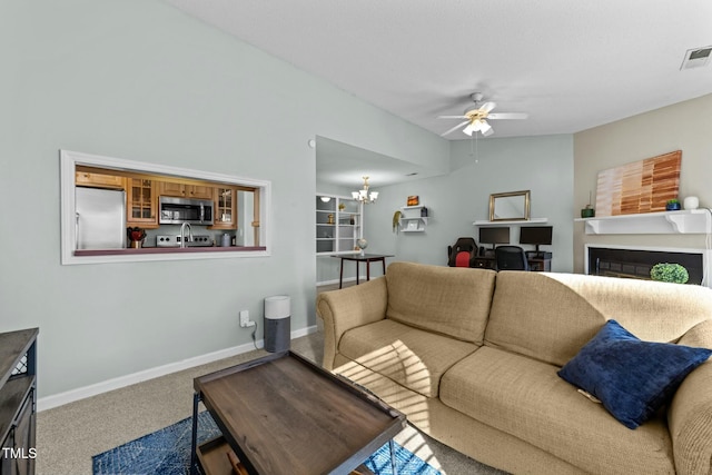 living room with carpet flooring and ceiling fan with notable chandelier