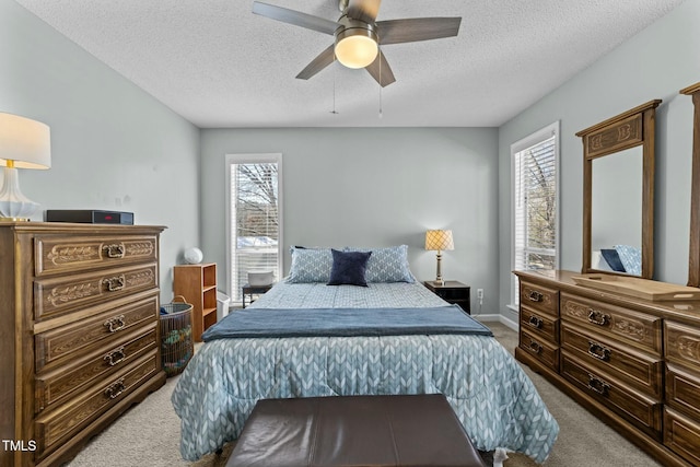 carpeted bedroom with a textured ceiling and ceiling fan