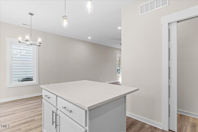 kitchen with ceiling fan with notable chandelier, light hardwood / wood-style floors, and white cabinetry