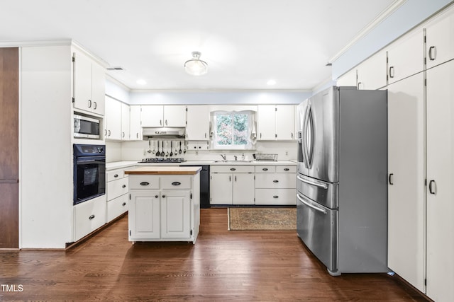 kitchen with sink, white cabinetry, appliances with stainless steel finishes, dark hardwood / wood-style flooring, and a kitchen island